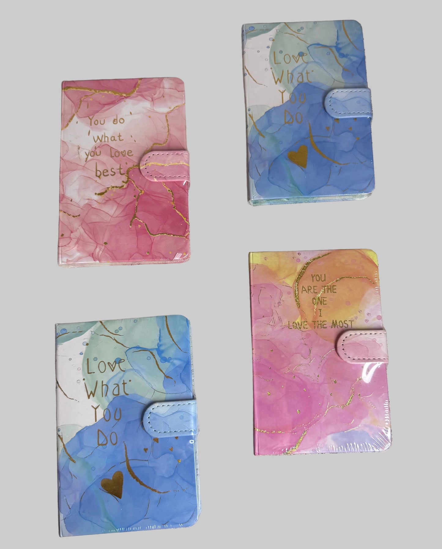 Four colorful notebooks with motivational text on a textured surface